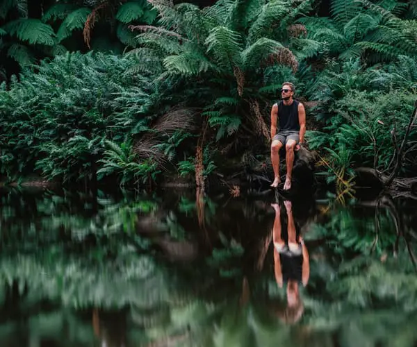 Man relaxing next to the water at Dip Falls in Tasmania